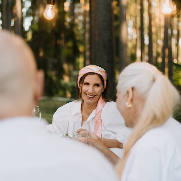 Smiling person meditating outdoors in a peaceful nature setting.